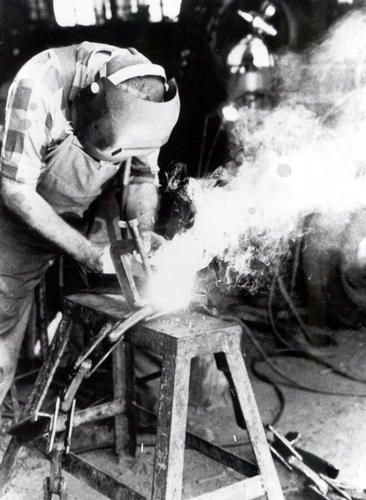 black and white photo of man welding