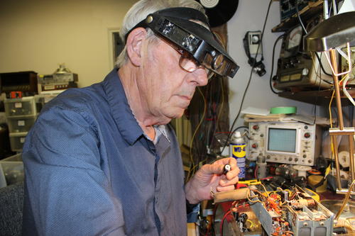man repairs antique radios