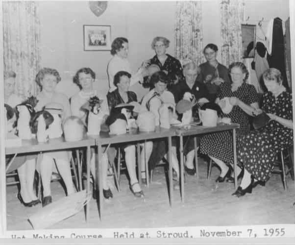 women seated at table with hat making supplies in front of them