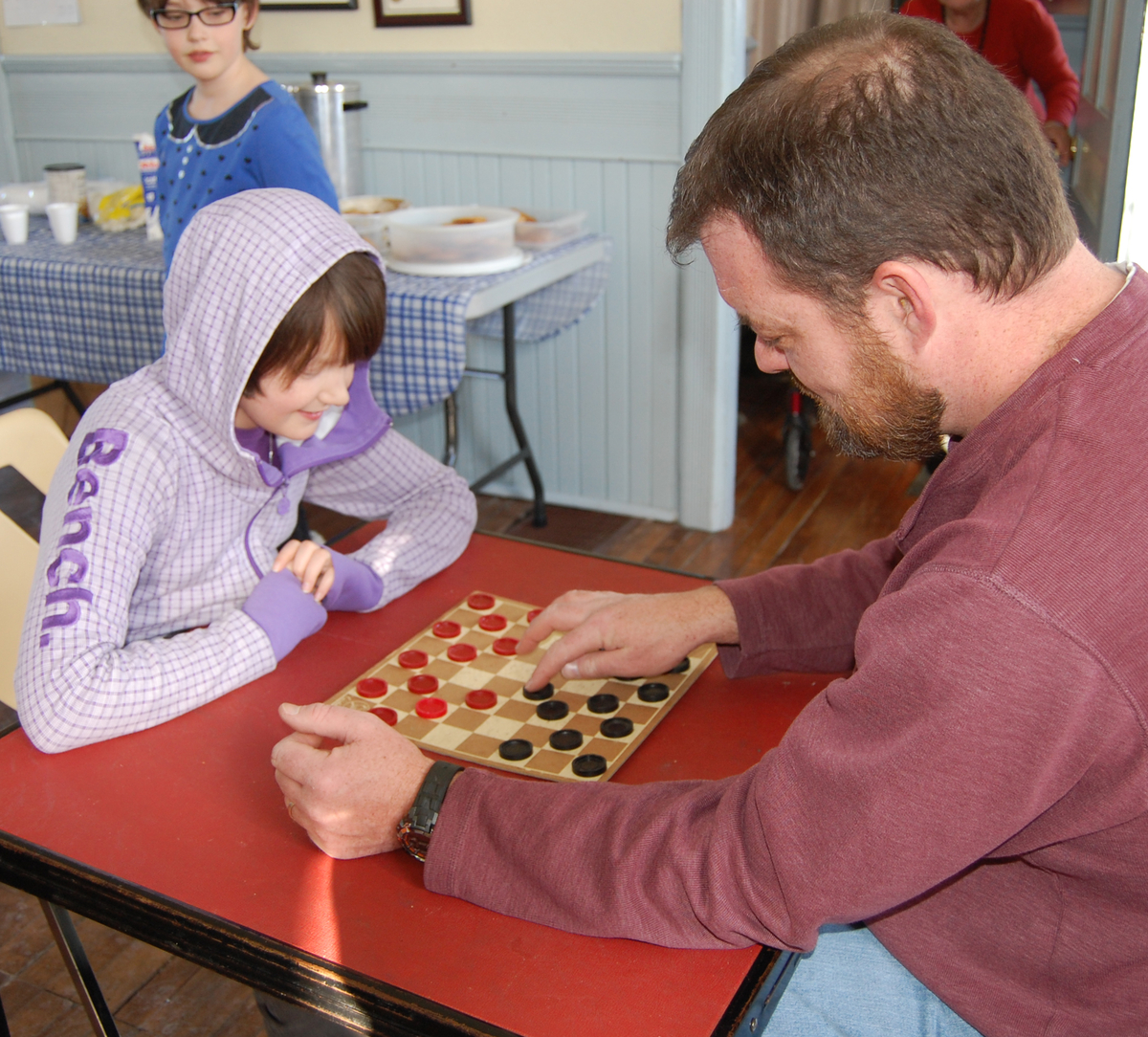 Father and daughter play checkers